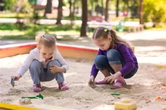 Who is the girl swinging in sandbox?