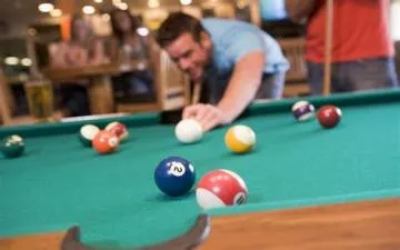 Can you sit on a pool table while taking a shot?